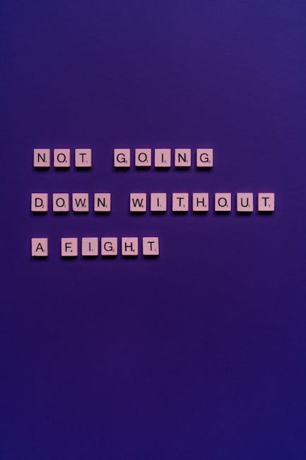 Close-up image of a blue background with the word 'FRI YAY' spelled out in beige, cut-out letters. The letters are arranged in two words with a small gap between 'FRI' and 'YAY'. The photograph emphas